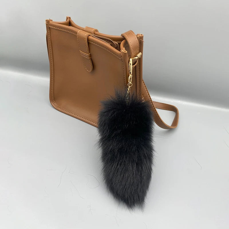 A playful fur tail bag charm for handbags, backpacks, keys, luggage, and everyday styling.